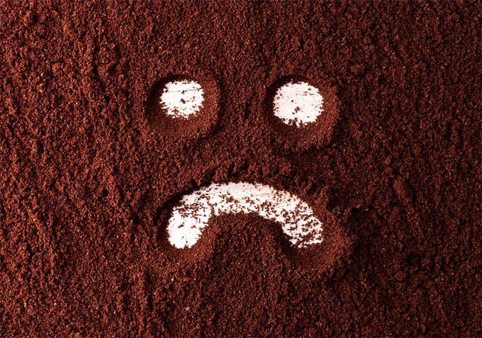 Sad smiley painted in coffee powder.