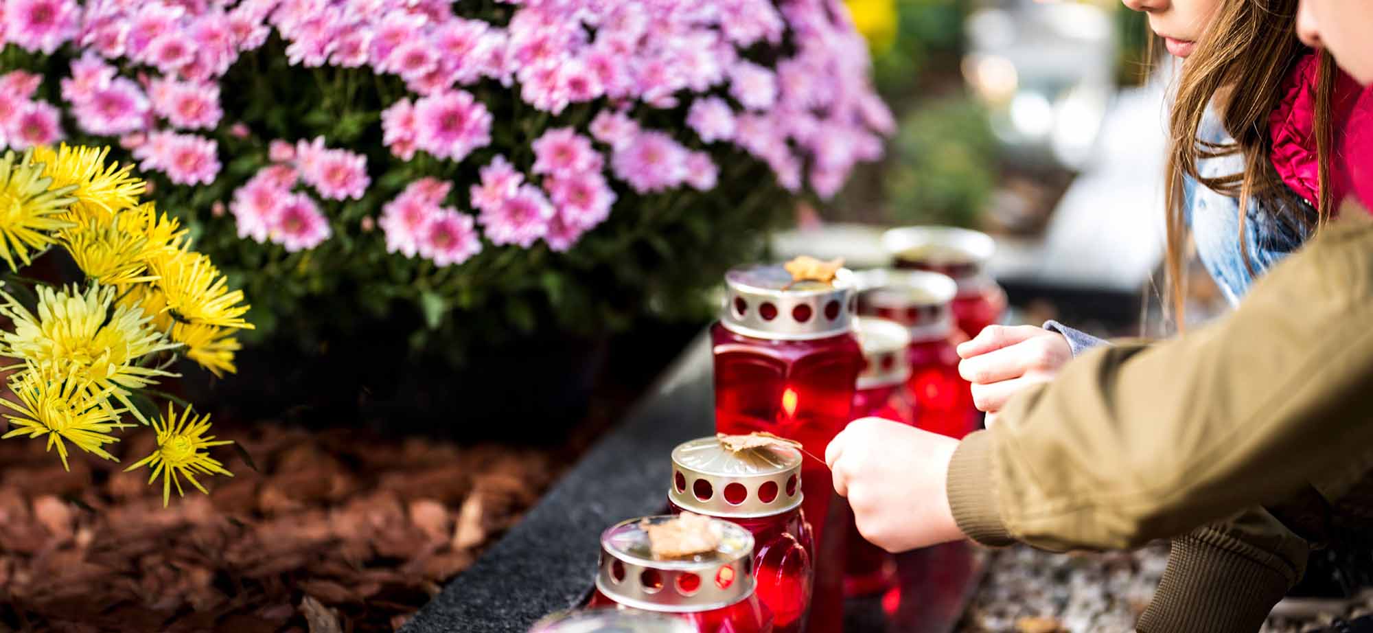 Children take care of oil lamps at the grave.