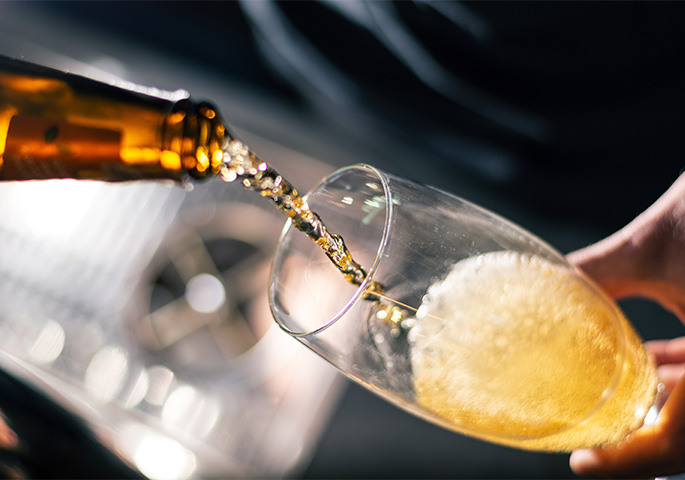 Beer is poured into a pilsner glass.