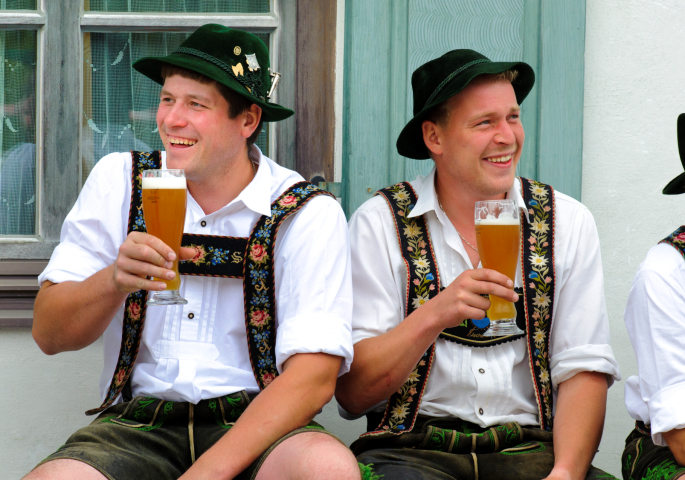 Bayerische Männer in Tracht mit Weizenbier