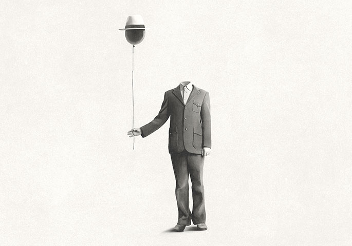 Headless gray man in suit holds air balloon with hat.
